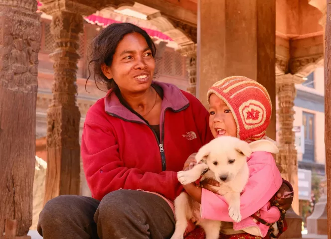 Une mère, sa fille et leur chiot dans les rues du Népal