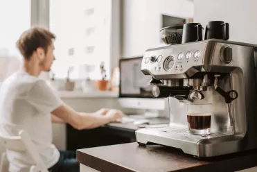 Homme dans un bureau et machine a cafe