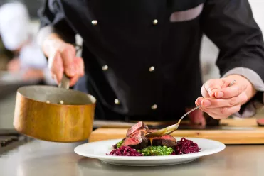 Chef en train de saucer un plat