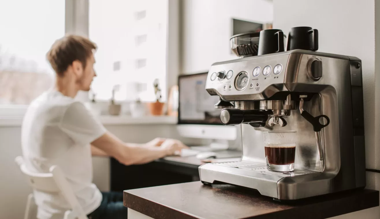 Homme dans un bureau et machine a cafe
