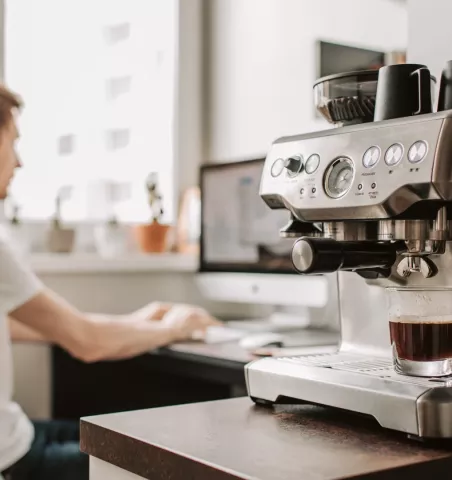 Homme dans un bureau et machine a cafe