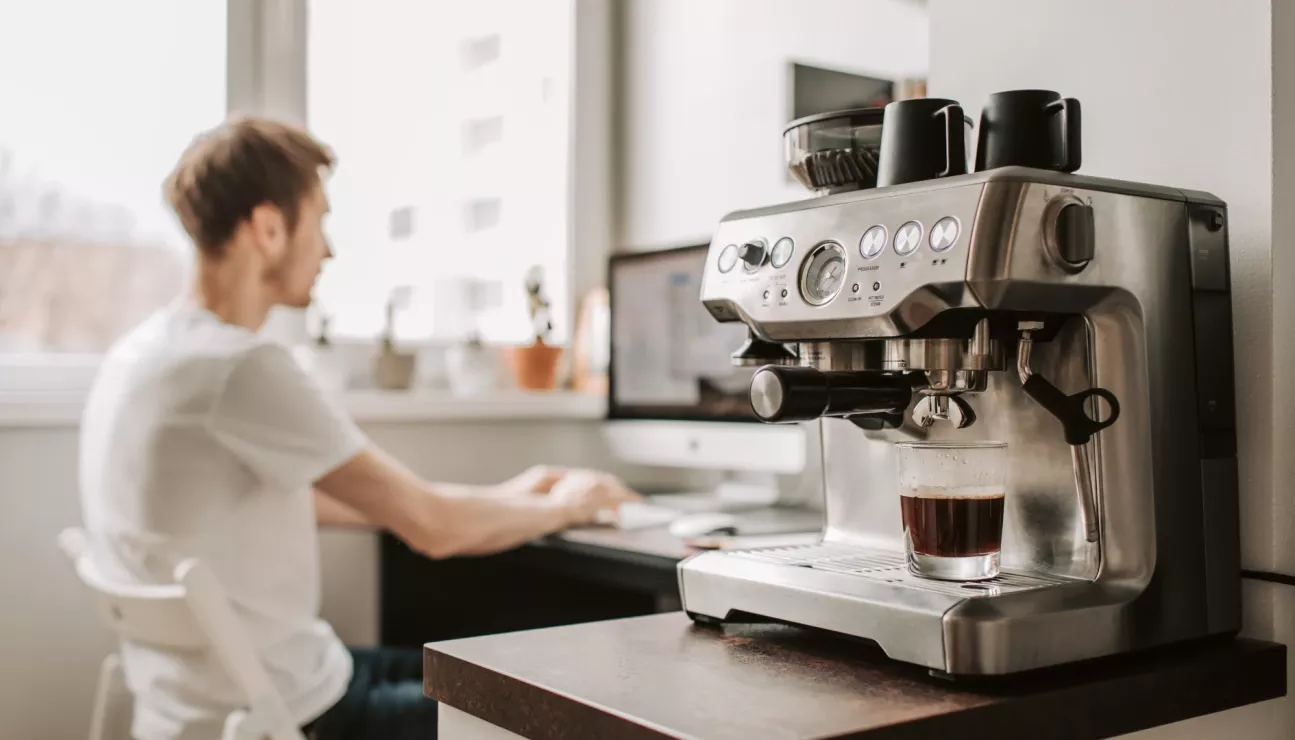 Homme dans un bureau et machine a cafe