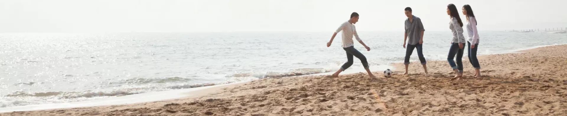 Amis jouant au ballon sur une plage