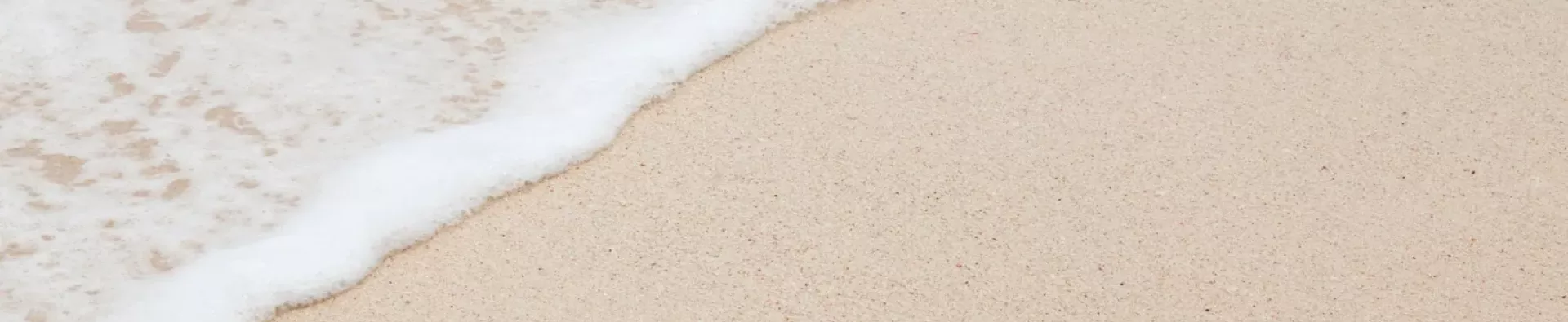 Vague qui revient sur une plage de sable